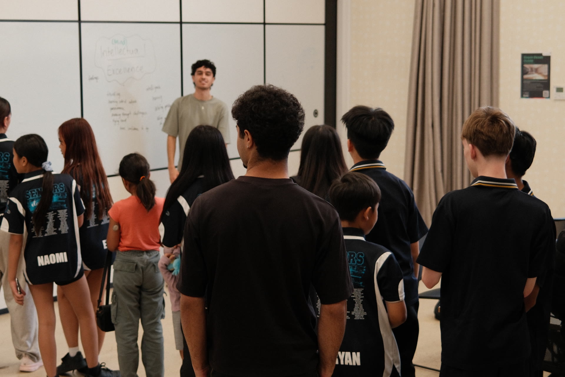 Youth gathered around an animator at the whiteboard
