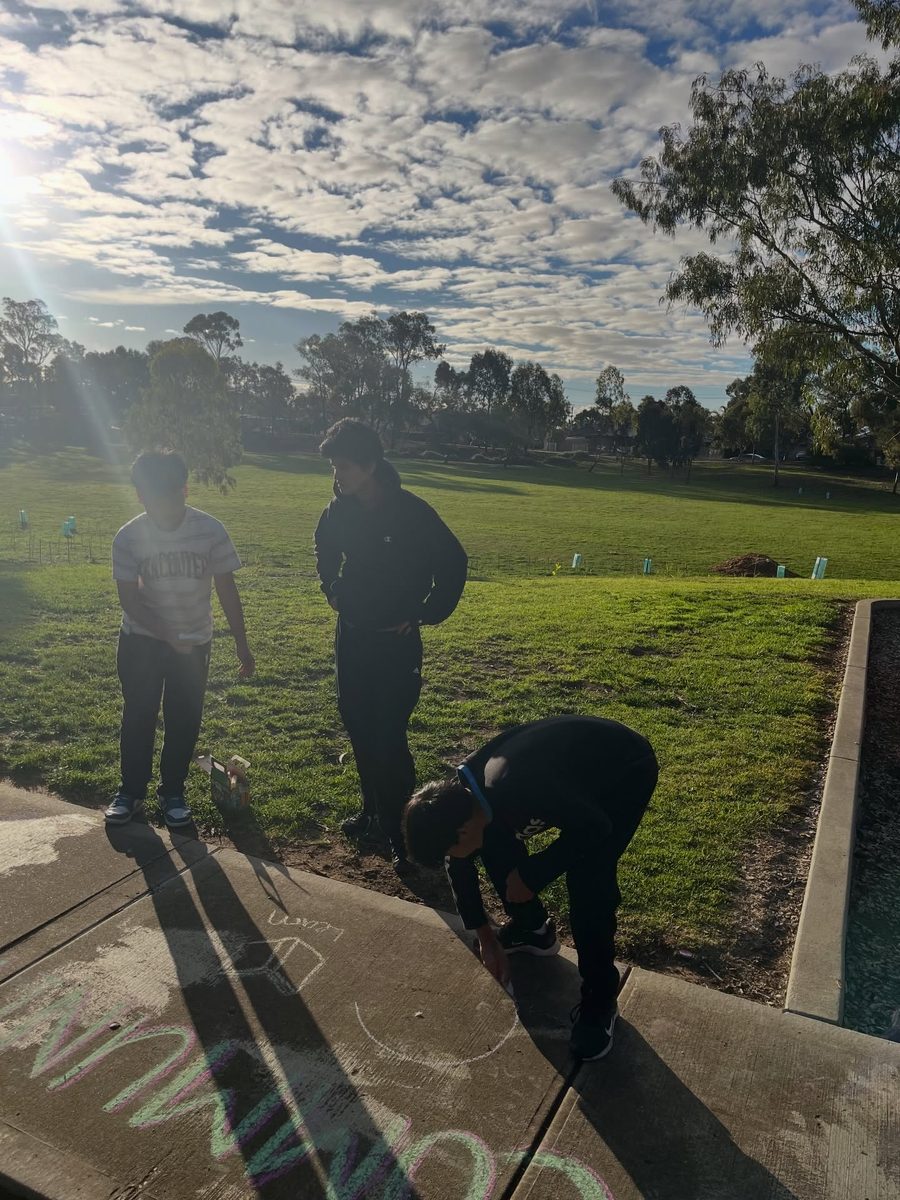 Junior youth chalking the path at the park
