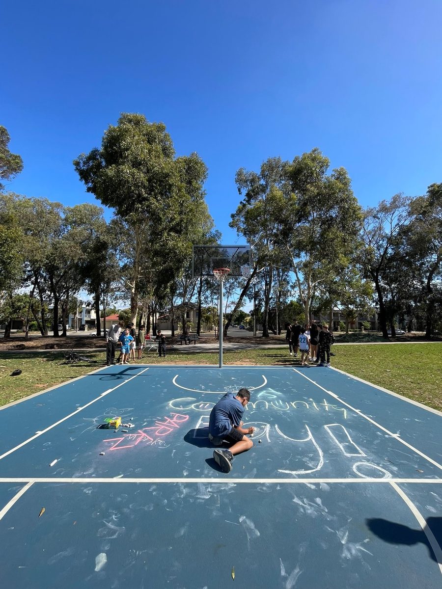 Chalking up the basketball court for Community Day at Reg Robinson Reserve
